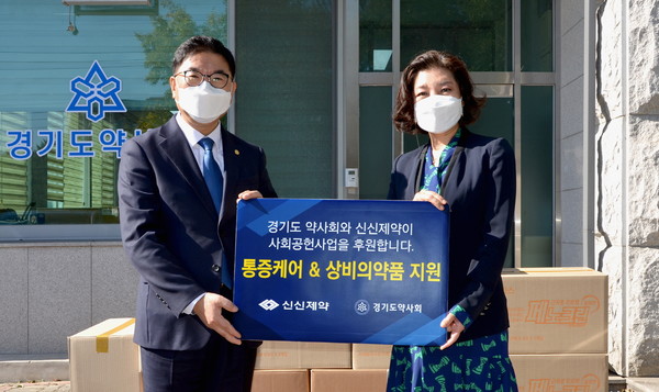 신신제약 마케팅본부 김상경 상무(오른쪽)가 경기도약사회 박영달 회장에게 후원 의약품을 전달하고 있다.