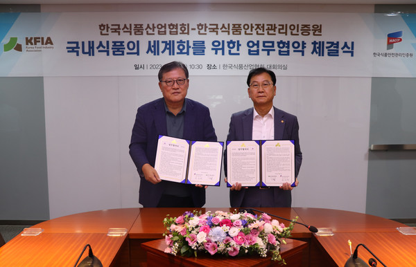 이효율 한국식품산업협회장(왼쪽)이 한상배 한국식품안전관리인증원장과 국내 식품의 세계화를 위한 업무협약을 체결하고 나서 기념촬영을 하고 있다.