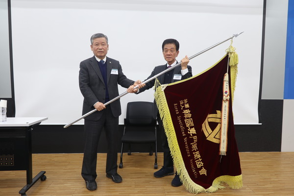 박두환 전임 회장(왼쪽)이 김광탁 신임 회장에게 협회기를 전달하고 있다.