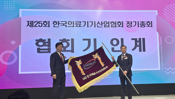 유철욱 전임 협회장(왼쪽)이 김영민 신임 협회장에게 협회기를 인계하고 있다.